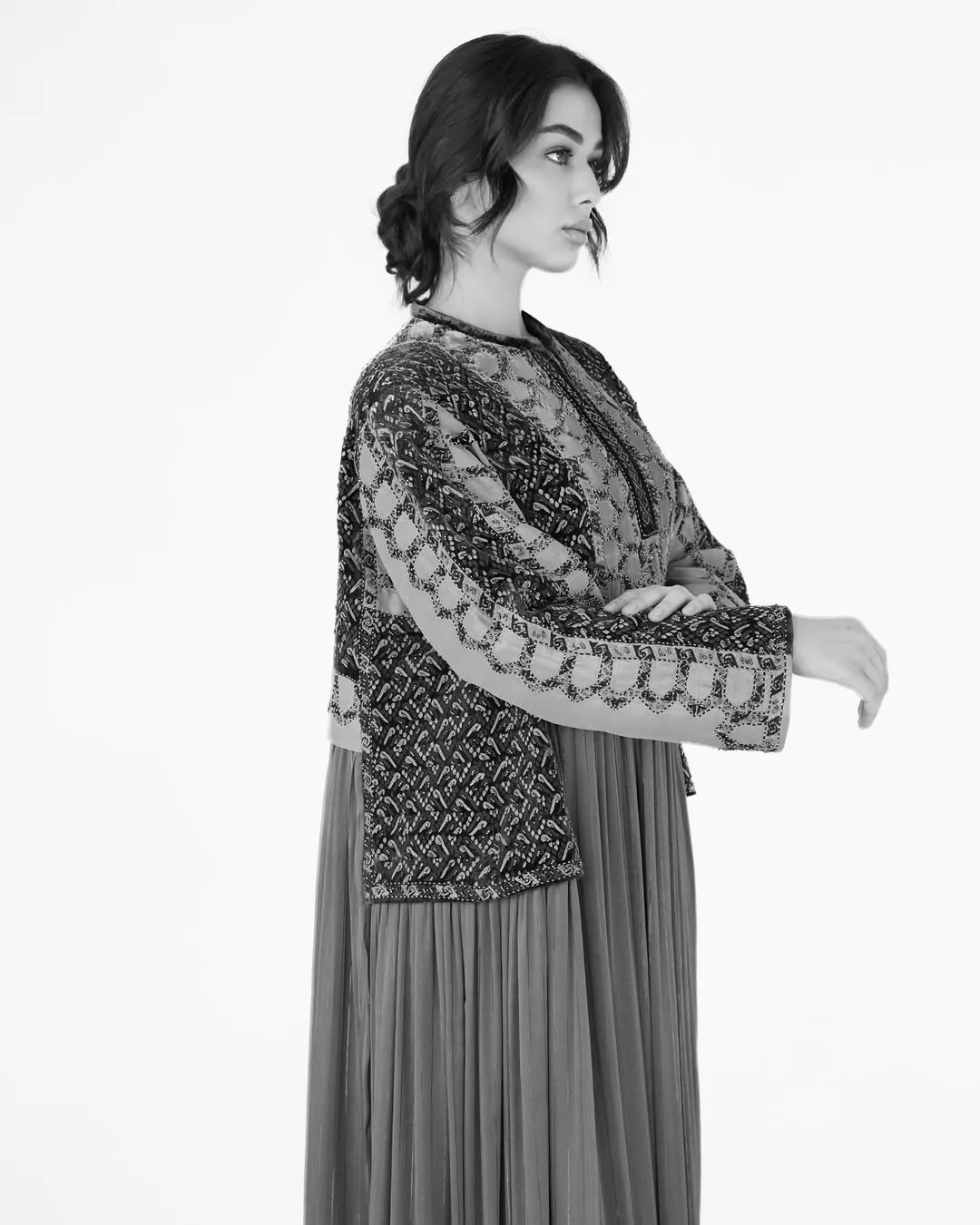 Black-and-white editorial portrait in pleated couture